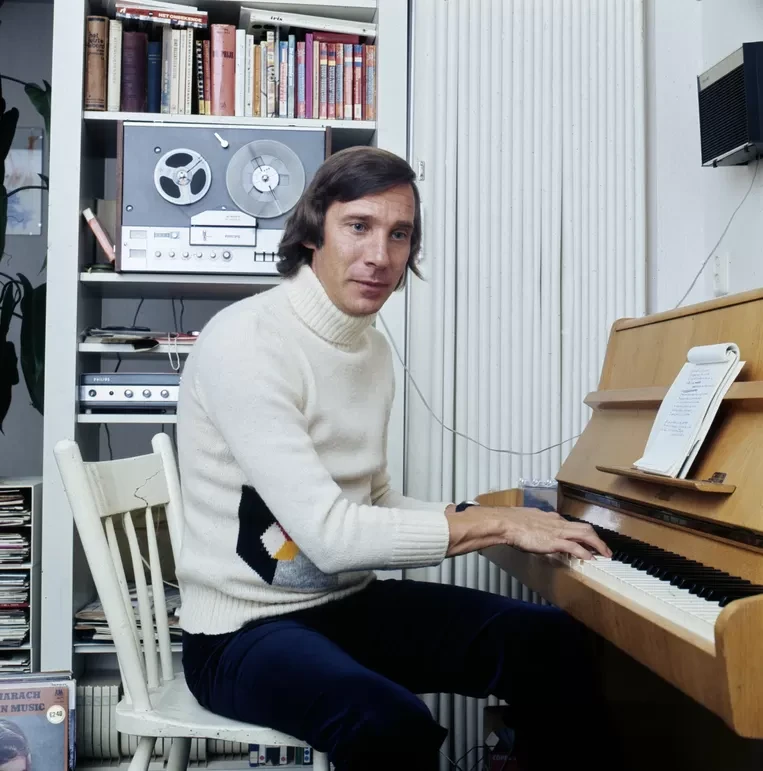 man op stoel achter piano