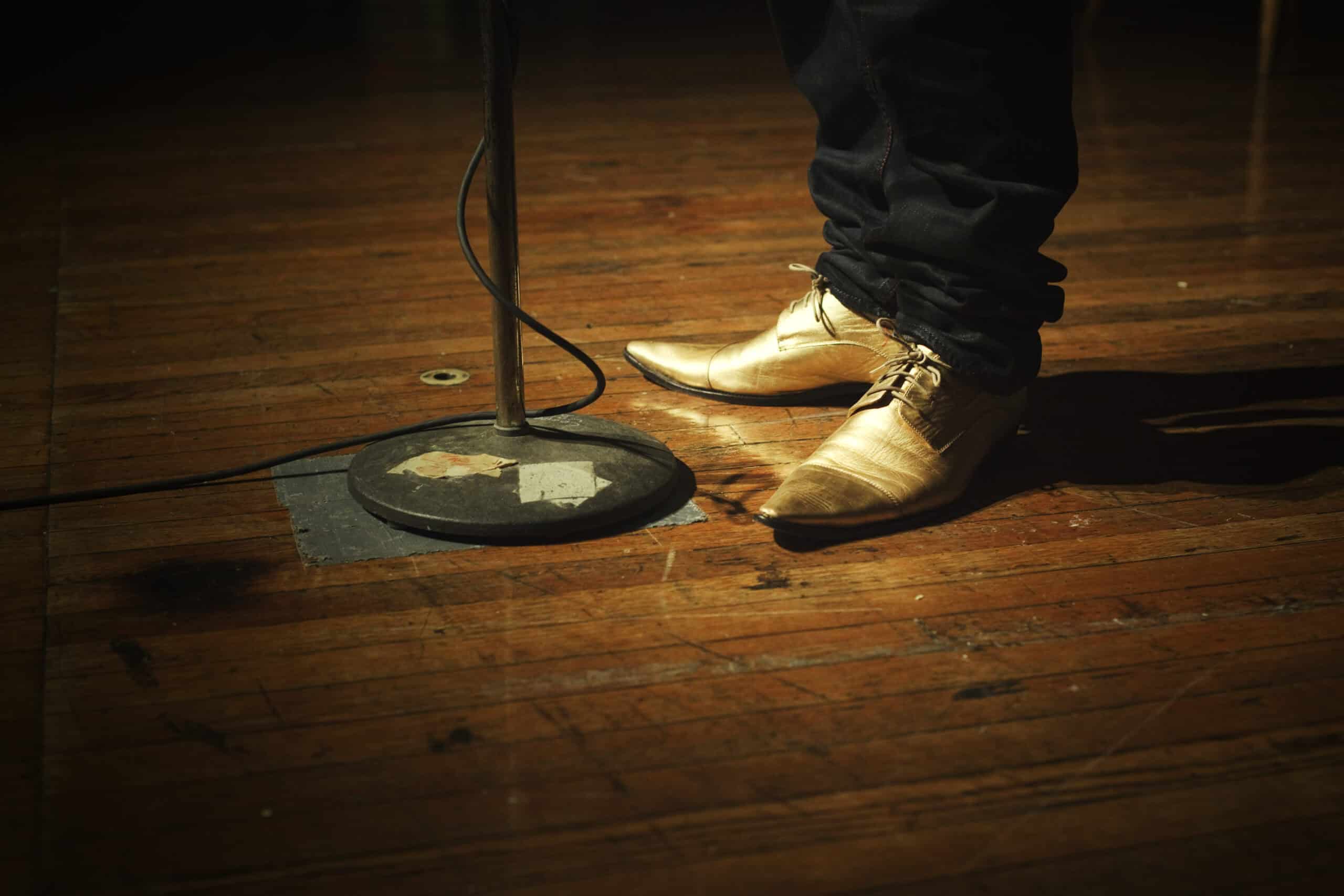 twee voeten op een podium met microfoonstandaard