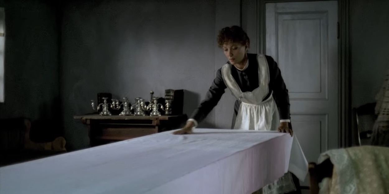 vrouw in donkere kamer die de tafel dekt