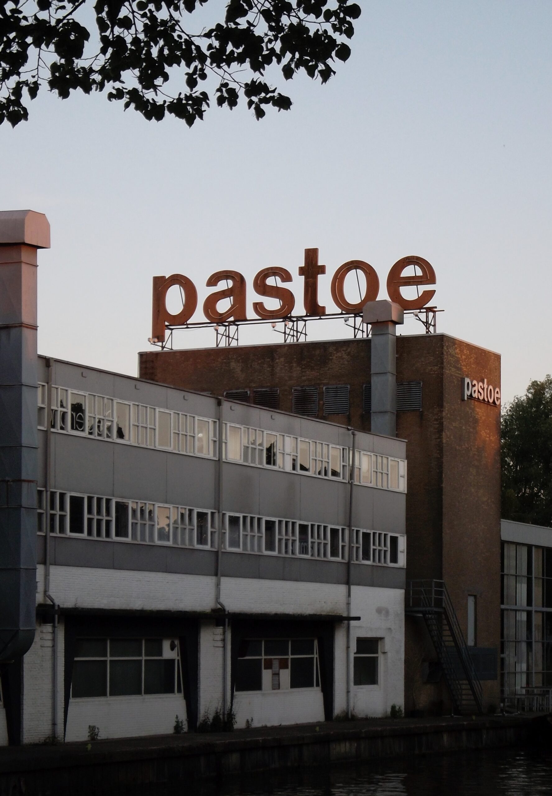 industrieel gebouw met gevelletters ‘pastoe’ op het dak