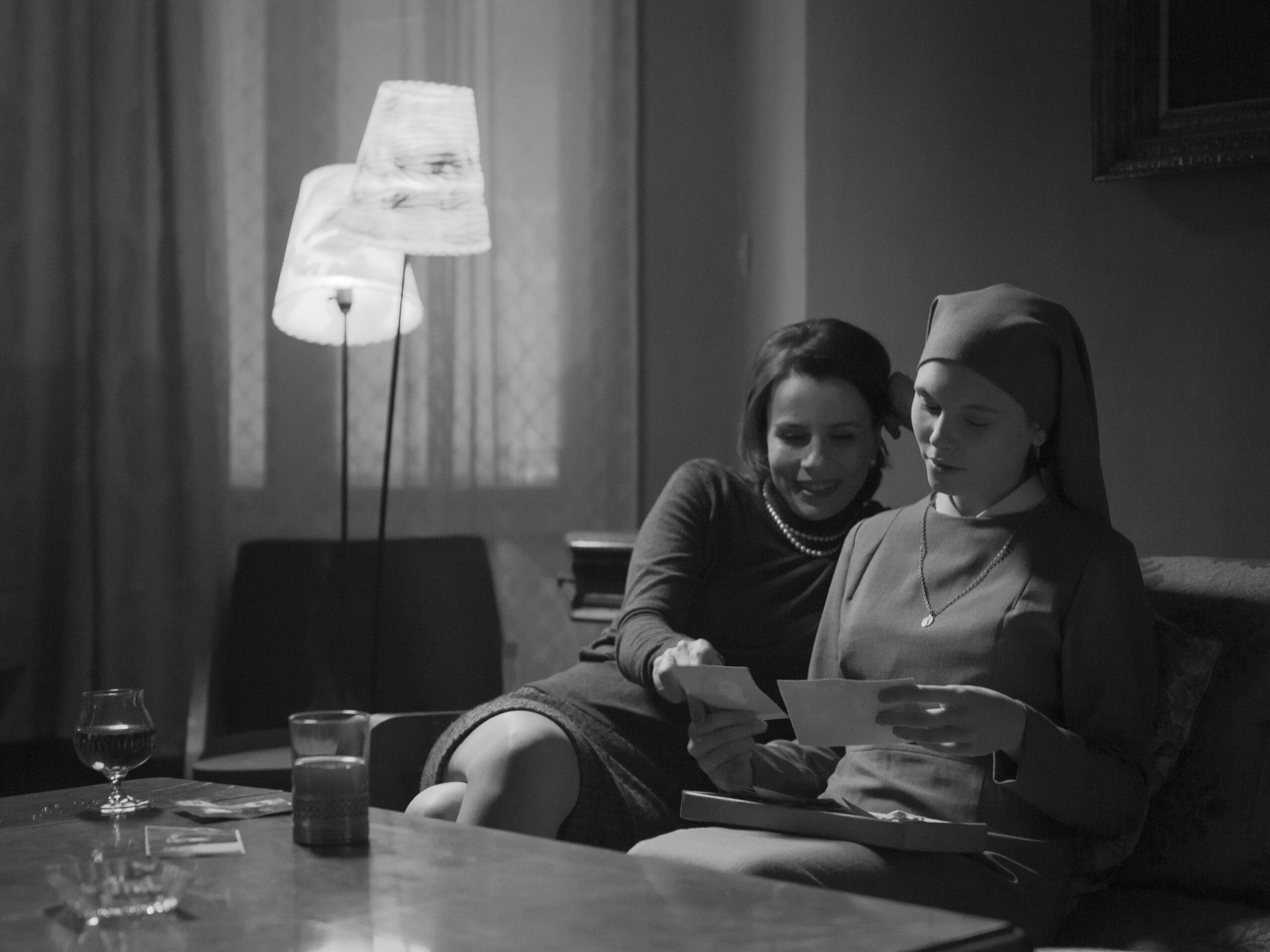 twee vrouwen op een bank, kijkend naar foto's